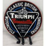 A cast iron circular shaped Triumph Bonneville wall plaque with key hooks. Painted black, white, red