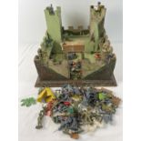 A vintage homemade wooden castle together with a quantity of assorted plastic toy soldiers.