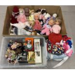 A large quantity of assorted vintage ceramic and vinyl dolls and dolls clothes. Dolls in varying