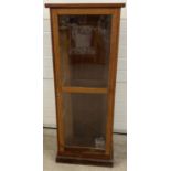 A tall dark wood glass fronted display cabinet on plinth base. Interior shelves missing. Approx. 137