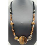 A 20" tigers eye and black onyx beaded necklace with silver tone S shaped clasp & spacer beads.