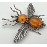A white metal amber set brooch/pendant in the shape of a flying insect. Body set with a round and