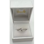 A boxed twist design platinum .10ct diamond solitaire ring by Chapelle. Tests as platinum, shows