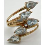A silver gilt spray design dress ring set with 5 teardrop cut pale blue topaz stones, by The Genuine