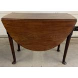 A Georgian mahogany oval topped, drop leaf dining table with pull out leg supports. Raised on