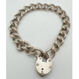A heavy silver curb chain charm bracelet with padlock clasp. Silver mark to back of padlock. Total