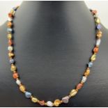 An 18" dyed freshwater keshi pearl necklace with gold tone S shaped clasp and spacer beads.