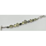 A modern design stone set bracelet with T Bar style clasp. Bracelet set with 7 bezel set faceted