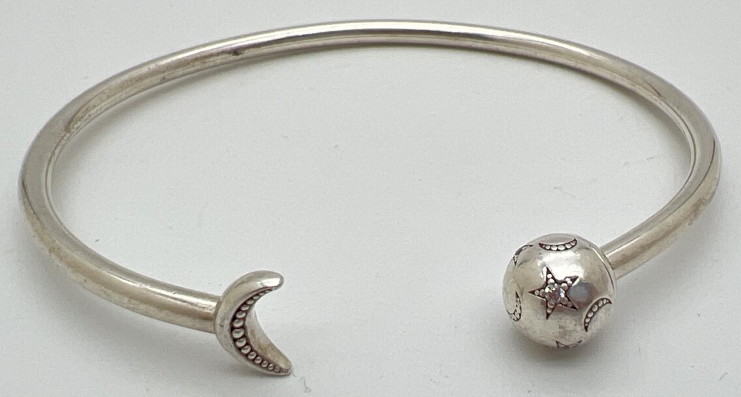 A silver star and moon stone set bangle by Pandora. Pandora silver marks to inside of bangle and