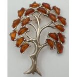 A 925 silver pendant/brooch in the shape of a tree, set with 19 small pieces of cognac amber.