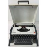 A vintage Olympia Traveller plus typewriter with carry case lid in grey and white. Approx. 30 x 31.