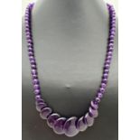 A 19" amethyst beaded necklace made from spherical and flat disc shaped beads. With silver tone S