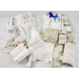 A box of assorted vintage table linen, doilies, napkins and lace trim.