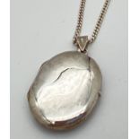 A plain oval silver locket on an 18" curb chain with spring ring clasp. Silver marks to inside of