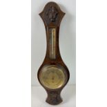 A vintage dark oak cased wall barometer with integral thermometer. Carved foliate design to oak