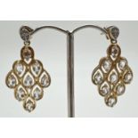 A pair of silver gilt chandelier style drop earrings each set with 9 clear oval cut stones, by The