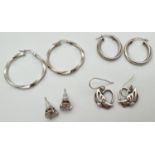 4 pairs of silver earrings. A pair of twist design hoops, a pair of clear stone set studs, a pair of