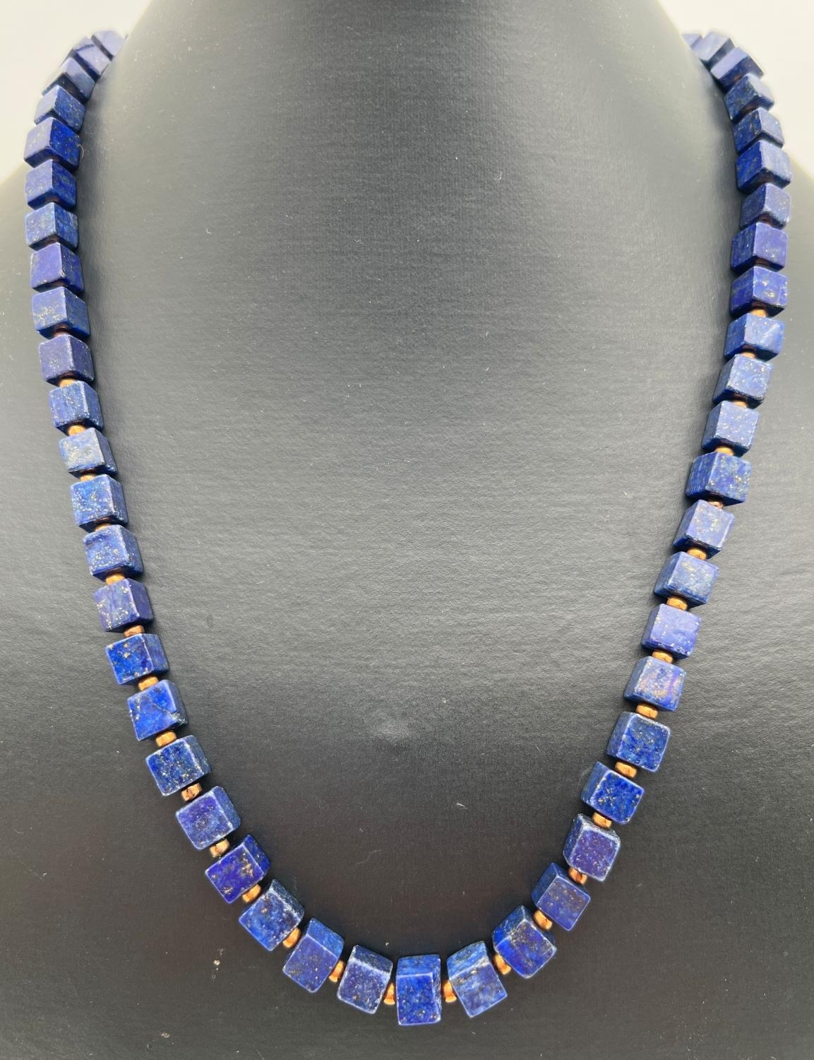 A 19" lapis lazuli beaded necklace of cube shaped beads, with gold tone S shaped clasp & spacer