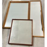 3 wooden framed wall hanging mirrors in various sizes. 2 square mirrors with a tall mirror.