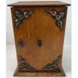An early 20th century oak smokers cabinet with Arts & Crafts style copper panels applied to door.