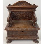 A late Victorian sewing box modelled as a highly carved monks bench with claw feet. With ornately