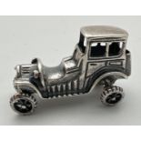 A small 925 silver model of a vintage veteran car with moving wheels. Stamped 925 to underside.