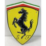 A painted cast iron wall plaque in the form of the Ferrari logo. With wall fixing holes, approx.