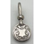 A Victorian silver napkin hook with engraved detail to circular clip. Decorative scroll & foliate