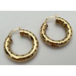 A pair of 9ct gold hoop earrings with polka dot decoration. Hallmarks to posts. Approx. 2.5cm