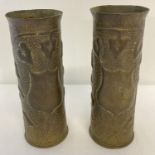 A pair of WWI era trench art shell case vases with hammered effect and ivy leaf detail. Approx. 23cm