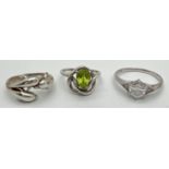 3 modern design dress rings. A wrap around Dolphin ring, a hexagonal cut clear stone solitaire and a