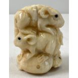 A small carved netsuke modelled as a stack of mice with polished finish and signature to