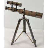 A brown leather bound brass desktop telescope on a folding tripod stand. Approx. 30cm tall.