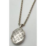 An oval shaped silver locket with engraved lattice design to front, on a 20" belcher chain with