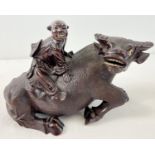 An antique carved hardwood Oriental figure of a Chinese man atop a water buffalo. Carved from one