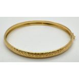 A modern silver gilt bangle with engraved diamond pattern throughout. With push clasp and safety