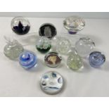 A collection of assorted glass paperweights to include coloured & clear glass and weights shaped