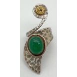 A silver contemporary design statement ring with copper and brass accents and green cabochon