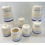 6 lidded ceramic kitchen storage jars by Arthur Woods. Cream ground with yellow and blue bands,