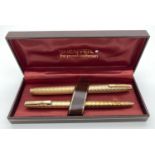 A boxed Sheaffer gold plated fountain pen and matching ball point pen with engraved engine turned