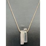 A modern design silver pendant necklace in brushed and plain silver, by Liga. Silver and makers