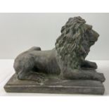 A large stoneware figure of a seated lion on a rectangular tile base, with a bronzed effect