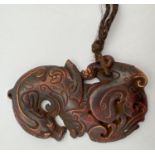 An oriental carved horn pendant modelled as a dragon. Approx. 9cm long.