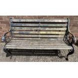 A vintage wooden slatted garden bench with cast iron bench ends, painted blue, with lions head