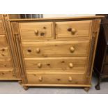 A modern 2 over 3 pine chest of drawers with twisted column detail and knob handles. With solid wood