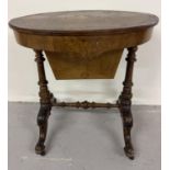 A Victorian walnut veneer sewing box on turned and carved legs with inlaid detail. Oval shaped