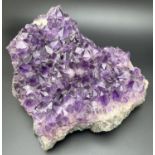 A large 3.7kg natural amethyst cluster geode with varying sized points. Approx. 23cm x 20cm at