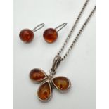 A flower design silver and amber pendant on a 20 inch curb chain with spring ring clasp. Together