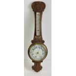 A 1920's oak cased banjo barometer with integral thermometer. Carved detail to case and engraved