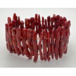 An elasticated bracelet made from long pieces of stem coral in a deep red/brown colour.